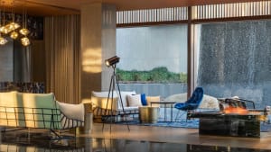 Modern living room with concrete floor, metal accents, and large windows.
