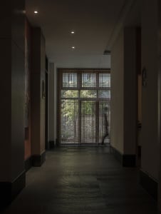 A modern interior design featuring glass elements and lighting in a corridor setting.