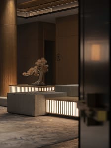 Modern lobby featuring concrete walls and natural lighting, illuminated by soft, ambient light, with a minimalist design and 