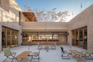 An outdoor courtyard with modern furniture and a wooden pergola.