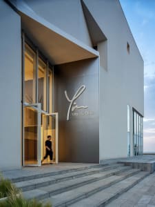 A modern, minimalist hotel entrance with a concrete facade and a sign reading 'YIN HOTELS'.