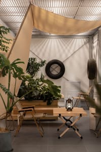 Park with wooden structures, industrial theme, and tires hanging on the wall.