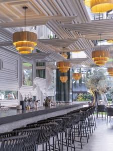 Modern, industrial-style restaurant bar interior with wooden accents and geometric ceiling