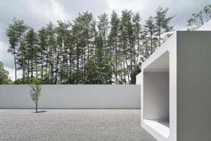 Modern architectural exterior featuring white walls and concrete elements.