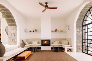 A modern living room with white walls, a fireplace, and concrete flooring.
