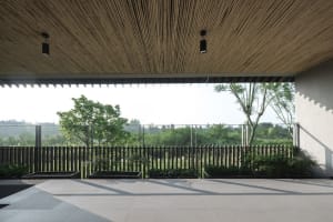 A spacious, modern residential veranda with bamboo ceiling, glass panels, and tile flooring.