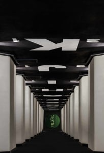 A minimalist corridor with black and white metallic elements.