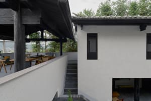 A modern residential exterior featuring concrete and stone materials.