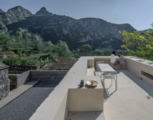 An outdoor patio with concrete flooring overlooking rugged mountain landscapes.