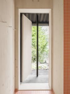 Modern minimalist entryway with wooden walls and a partially open door