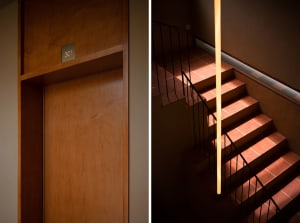 Modern staircase with wooden steps and black handrails.