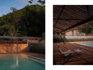 Modern swimming pool with metal and stone features, surrounded by natural landscape.