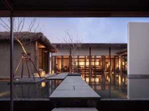 A minimalist landscape design featuring concrete, water, and wooden elements created by a single photographer.