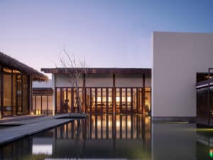Modern minimalist residential interior featuring wood, glass, and concrete materials.