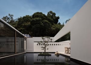 Modern residential space featuring glass, wood, and concrete materials.