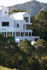 White residential building surrounded by trees and mountains