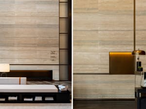 A modern minimalist lobby with a marble wall and floor, featuring sleek and contemporary design.
