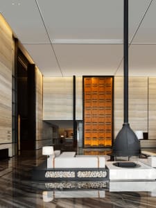 Modern hotel lobby featuring wood accents, stone flooring, and metal elements