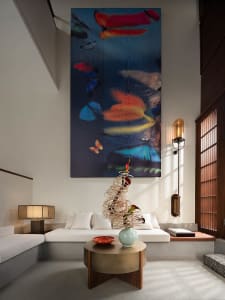 A modern living room with a large abstract art piece featuring colorful butterflies on the wall.