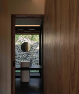 Modern bathroom with stone walls and a wooden vanity.