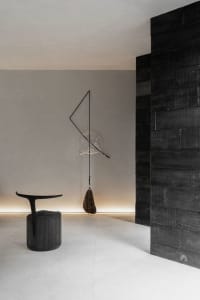A minimalist space featuring a modern interior with concrete floors, black walls, and wooden details.