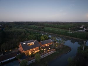 A modern residential brick house with large windows and a roofline designed to capture natural light.