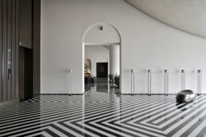 A modern minimalist entryway featuring a concrete and glass design.