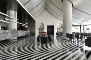 A modern restaurant with a concrete floor featuring geometric patterns.