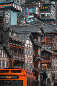Traditional Chinese village with wooden frame construction and terracotta lanterns hanging from eaves.