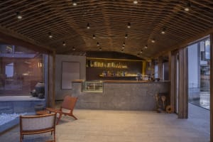 A modern cafe bar featuring stone, concrete, and wooden materials