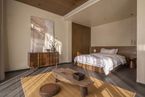 Modern minimalist bedroom featuring wooden furniture and a neutral color palette.