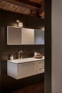 Industrial-style bathroom with metal sink, concrete tiles, and modern fixtures.