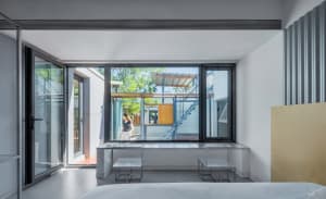 Minimalist residential space featuring a white wall and floor with large glass windows.