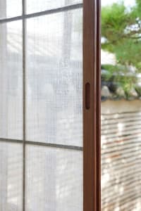 A close-up of a traditional window with a wooden frame, showcasing the texture and craftsmanship.
