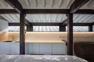 Interior space featuring white wood beams and concrete surfaces.