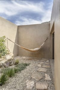 A minimalist residential patio featuring concrete and stone surfaces.