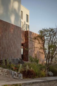 Modern residential exterior featuring clay tiles and concrete materials.