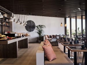 Modern restaurant interior with wooden furniture, metal accents, and ceramic elements.
