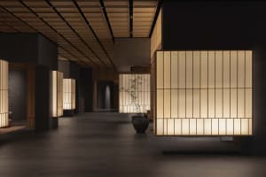 A modern and minimalist lobby featuring light wood materials and warm lighting.
