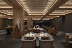 A modern restaurant interior with wooden tables and chairs, white linens, and ambient lighting.