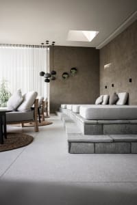 Interior design image featuring a modern, industrial relaxation space with concrete and stone materials.