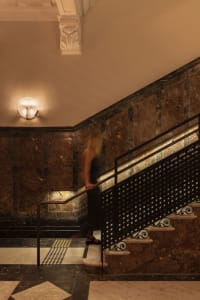A woman walking down a modern staircase made of marble.