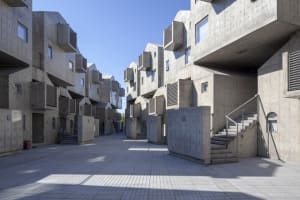 Concrete housing complex with geometric shapes and exterior walkways.