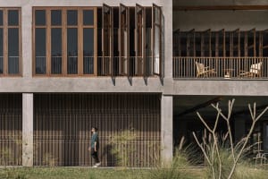 Modern building exterior featuring concrete, glass, and wooden elements.