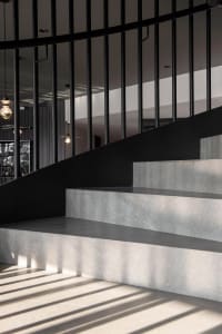 Concrete stairs with a minimalist design and black metal railing.
