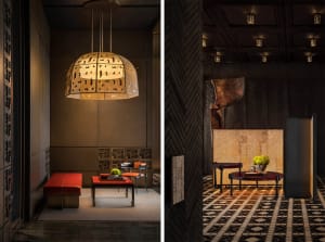 Industrial-style lobby featuring metallic pendant lighting, textured walls, and dark furnishings.