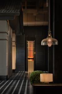 Cozy modern hotel lobby with wooden paneled walls and warm lighting.