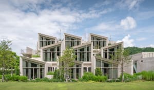 A modern residential building with concrete walls and large windows.