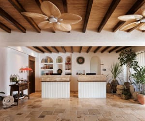 A modern reception desk with a stone countertop and wooden beam ceiling.