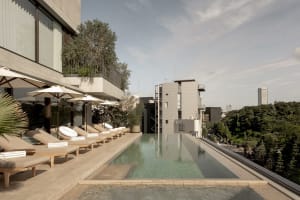 Outdoor hotel rooftop pool with concrete deck and lounge chairs.